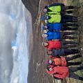 Group photo of demonstrators on the Assynt field course. They are wearing outdoor gear and are smiling at the camera with their arms wrapped around each other.