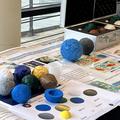 Photograph of a science fair display showing some planets made using a 3D printer. Posters discuss the layers on the earth and what they are made of.