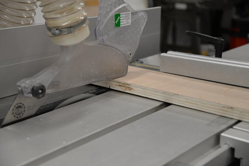 Machine sawing a plank of wood