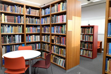 Photograph of large, full, wooden bookcases in the Department Library.